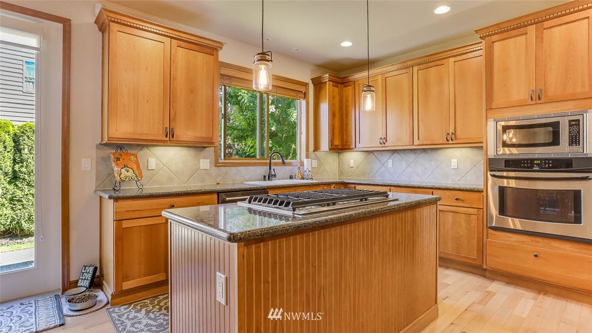 21131 37th Avenue Southeast Bothell, WA 98021 - Photo 16 of 40 a kitchen with stainless steel appliances granite countertop a stove a sink and a microwave