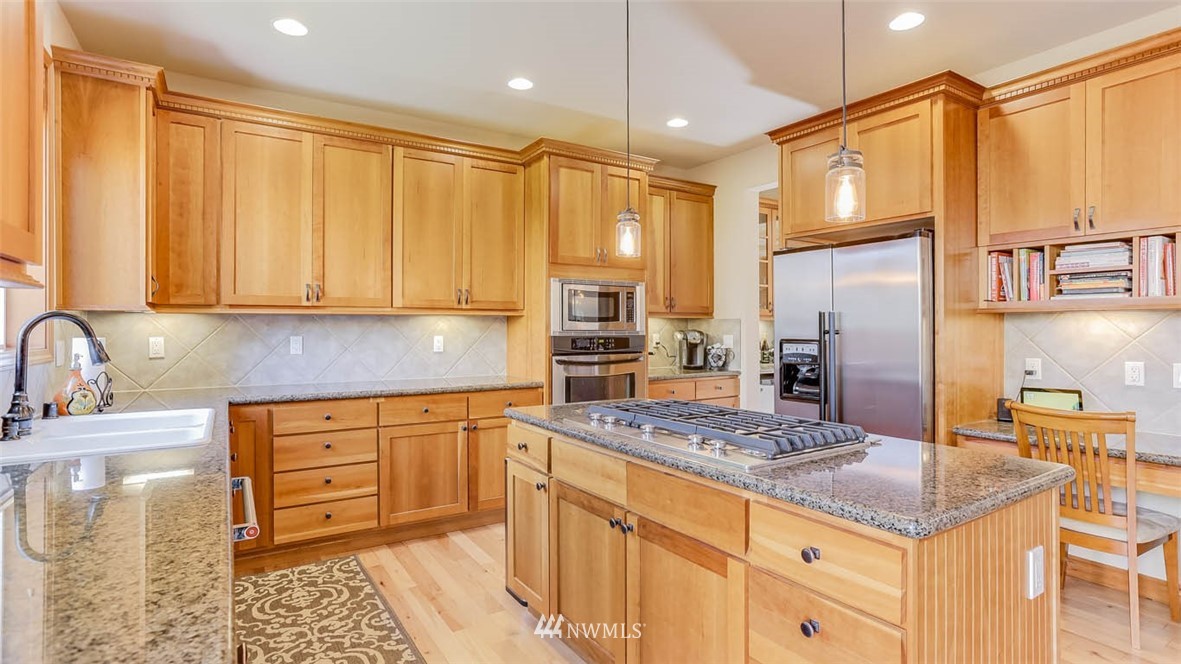 21131 37th Avenue Southeast Bothell, WA 98021 - Photo 20 of 40 a kitchen with stainless steel appliances granite countertop a sink stove and refrigerator