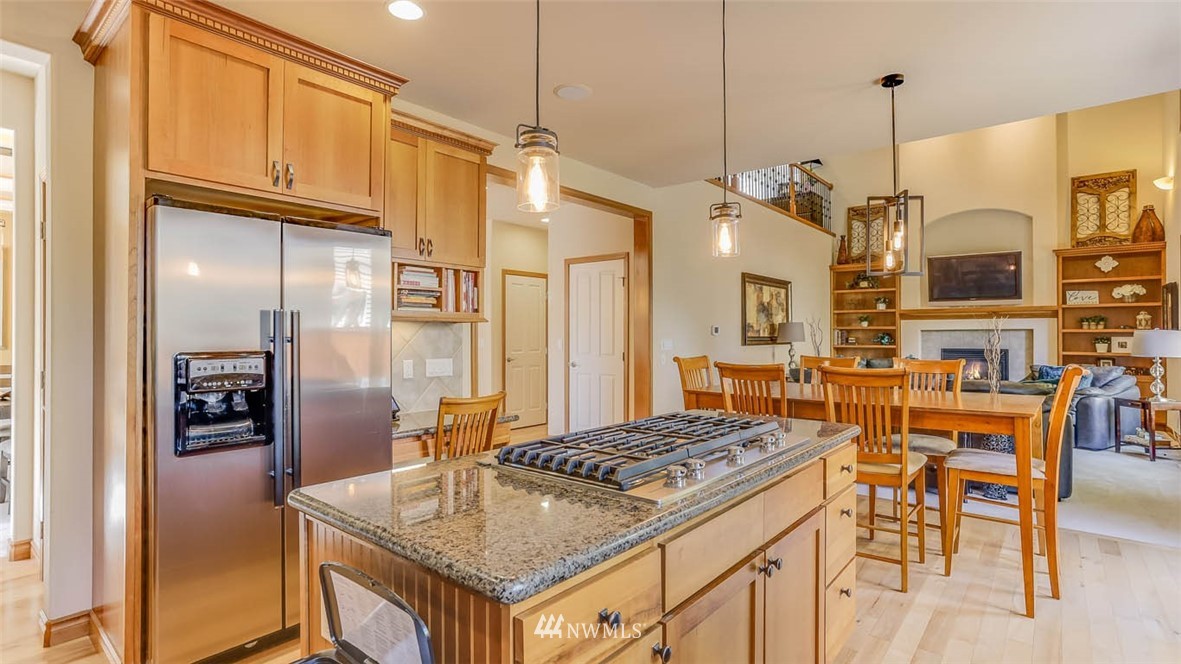 21131 37th Avenue Southeast Bothell, WA 98021 - Photo 21 of 40 a kitchen with stainless steel appliances granite countertop a table chairs and a refrigerator