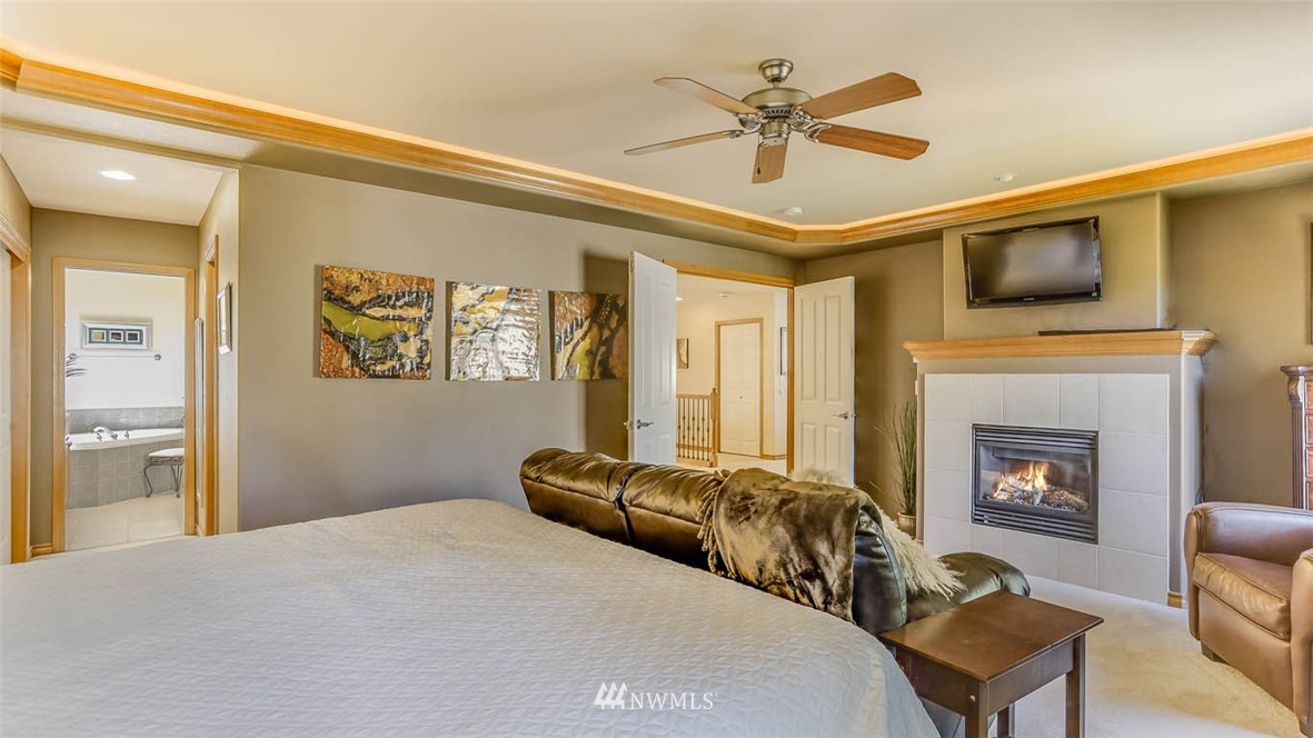 21131 37th Avenue Southeast Bothell, WA 98021 - Photo 27 of 40 a bedroom with a bed furniture and a fireplace