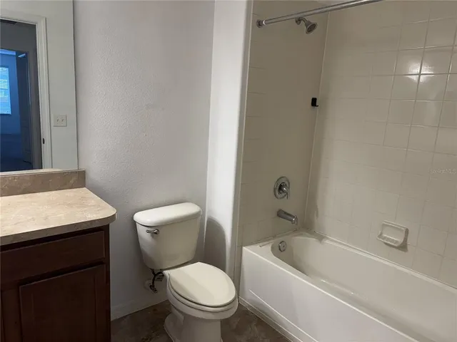 a white toilet sitting next to a bath tub