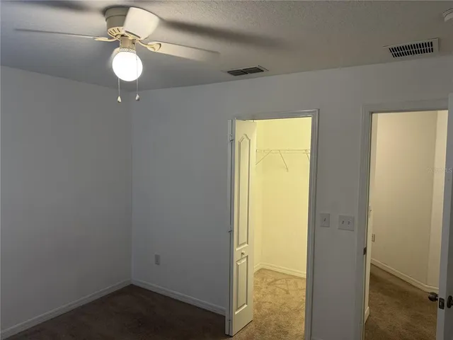 a view of a room with wooden floor and fan