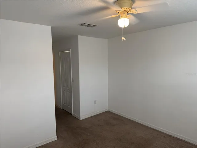 an empty room with a fan and a fan