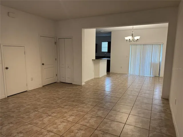 a view of a hallway with wooden floor and a living room