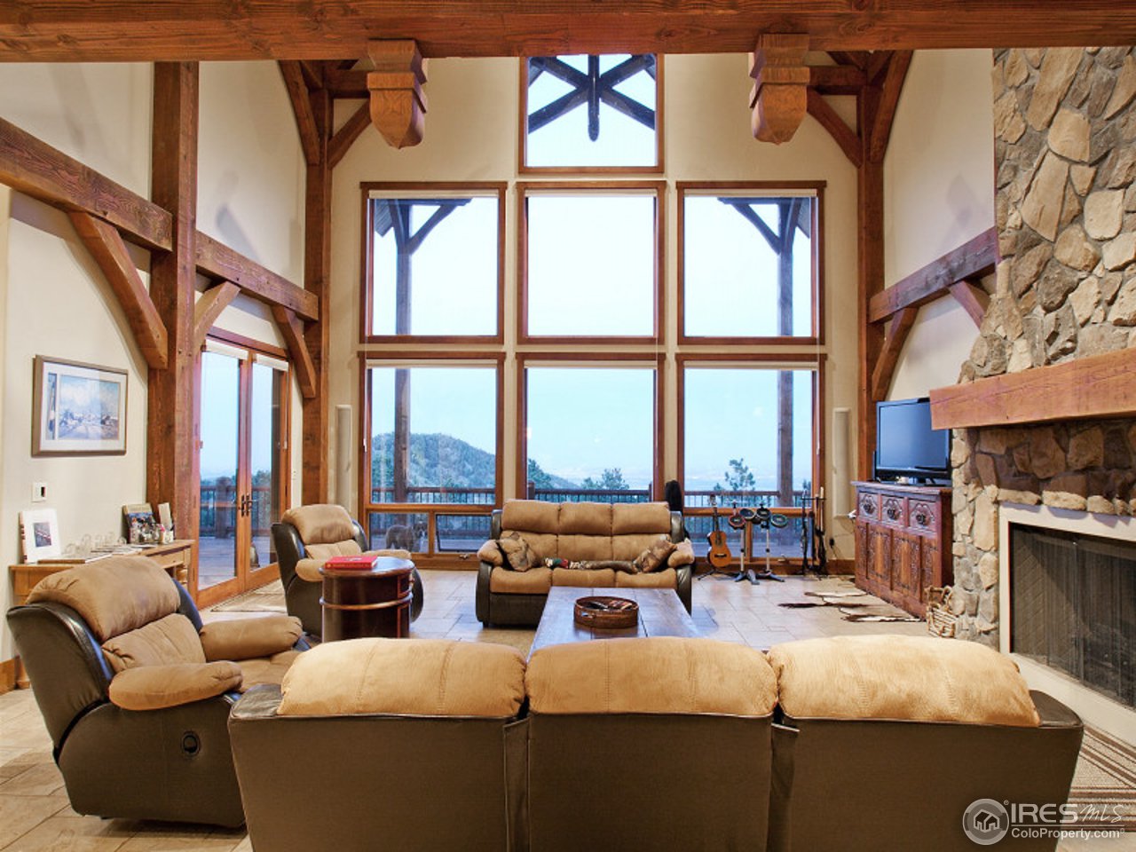 7654 Spirit Ranch Road Golden, CO 80403 - Photo 3 of 25 a living room with furniture fireplace and large windows