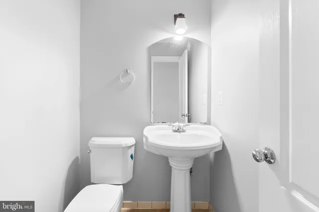a bathroom with a sink toilet and mirror