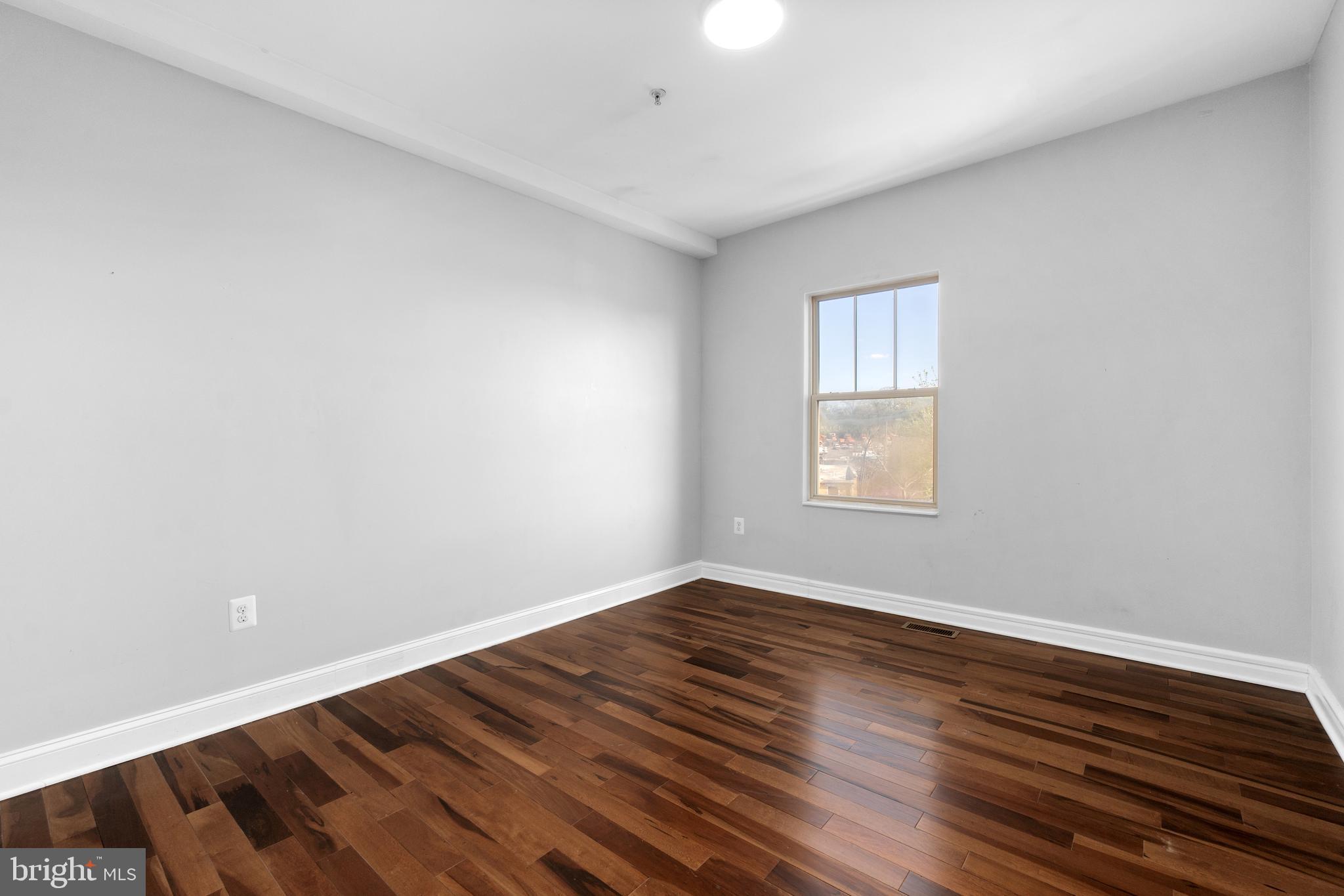 1829 Providence Street Northeast, Unit A Washington, DC 20002 - Photo 15 of 38 a view of an empty room with wooden floor and a window