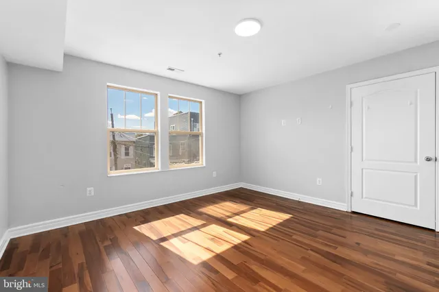 wooden floor in an empty room with a window