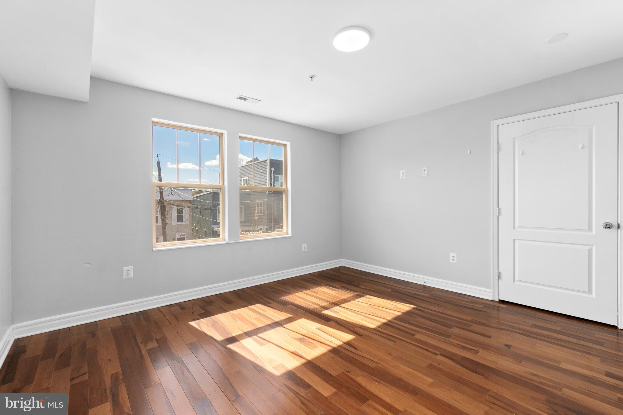 1829 Providence Street Northeast, Unit A Washington, DC 20002 - Photo 21 of 38 an empty room with wooden floor and windows