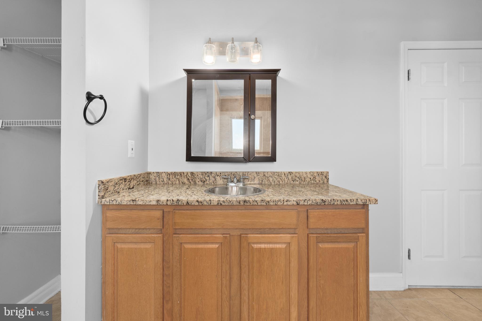 1829 Providence Street Northeast, Unit A Washington, DC 20002 - Photo 24 of 38 a bathroom with a granite countertop sink and a mirror