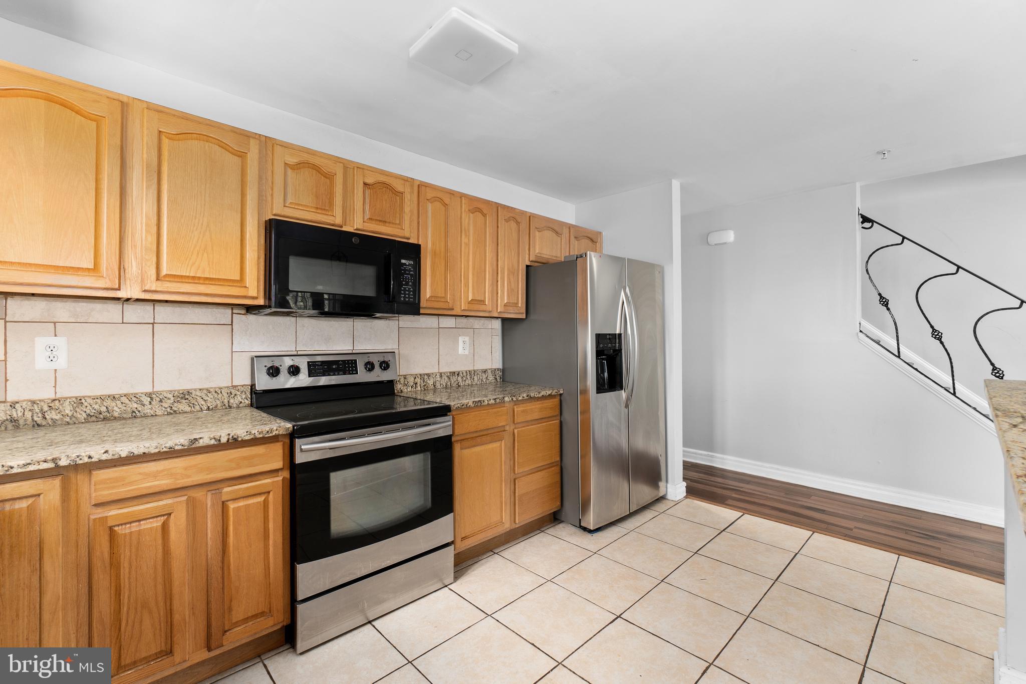 1829 Providence Street Northeast, Unit A Washington, DC 20002 - Photo 9 of 38 a kitchen with stainless steel appliances granite countertop a stove a sink and a refrigerator