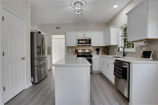 a kitchen with a refrigerator a stove top oven a sink and dishwasher