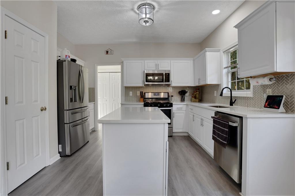 2760 Jona Trail Dacula, GA 30019 - Photo 15 of 40 a kitchen with a refrigerator a stove top oven a sink and dishwasher