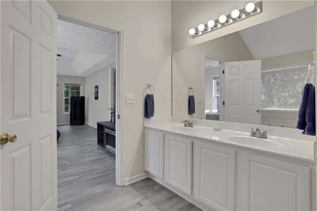 2760 Jona Trail Dacula, GA 30019 - Photo 24 of 40 a bathroom with a double vanity sink a mirror and a shower
