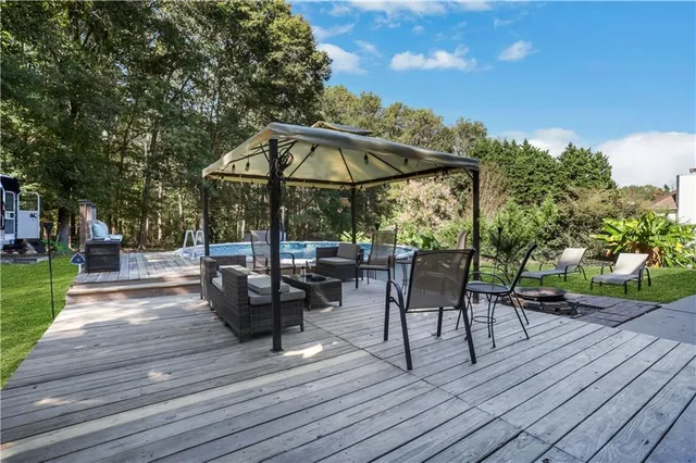 a view of a patio with table and chairs under an umbrella with wooden floor