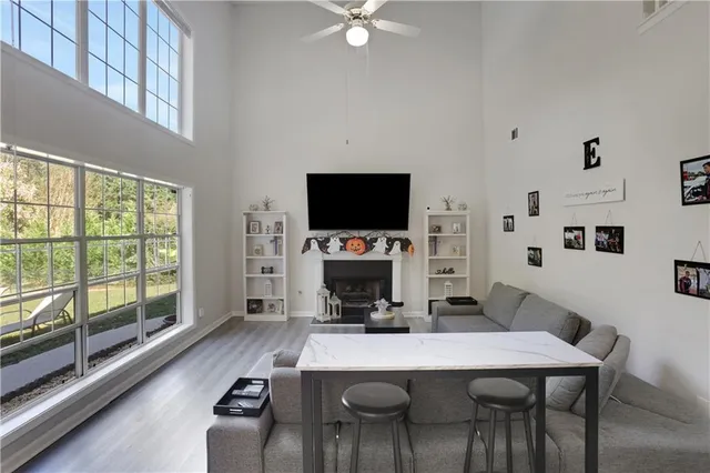 a living room with furniture a flat screen tv and a large window