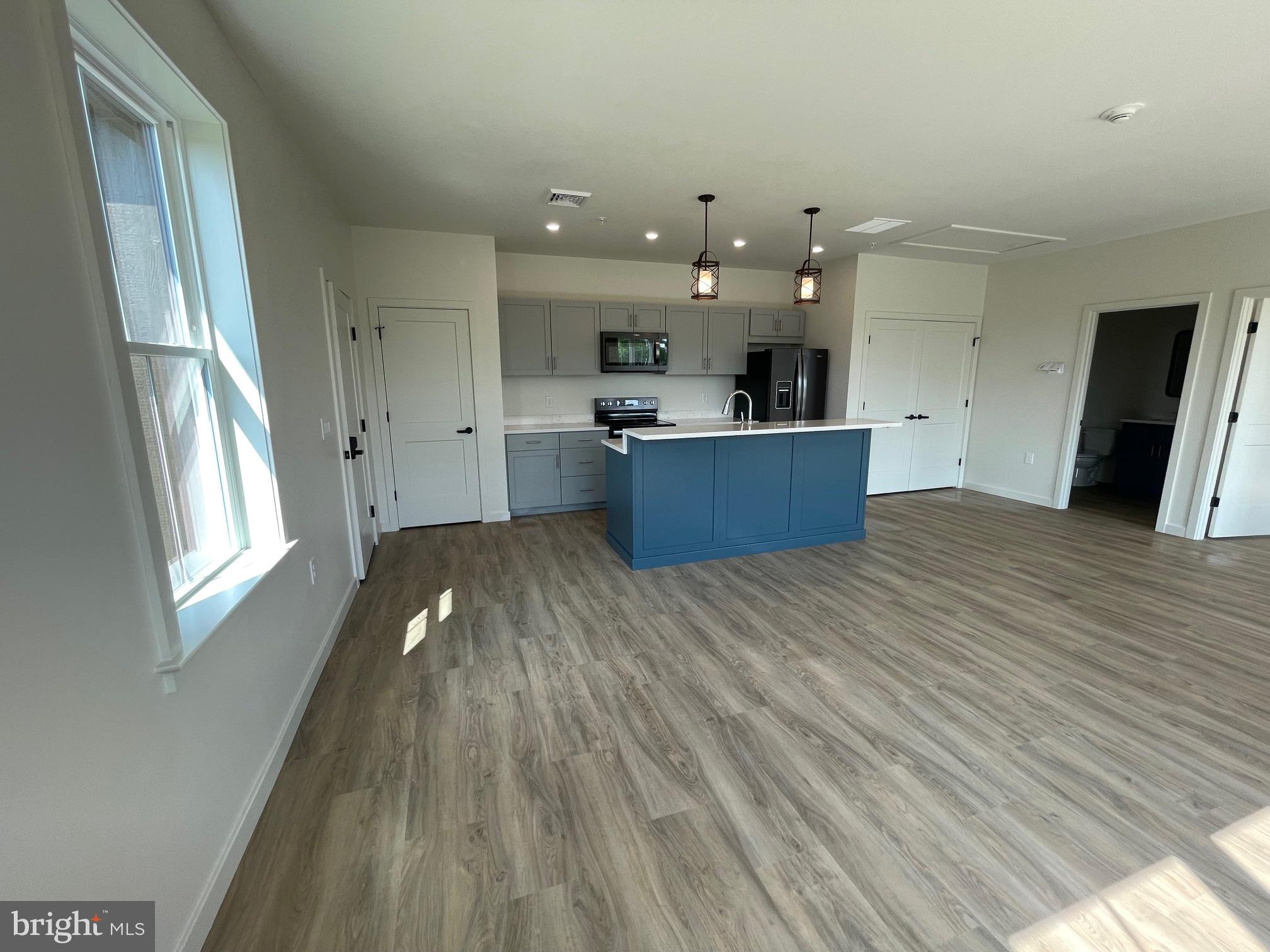 15 Kennedy Street Lancaster, PA 17602 - Photo 3 of 17 a view of a kitchen with kitchen island a sink wooden floor and a large window