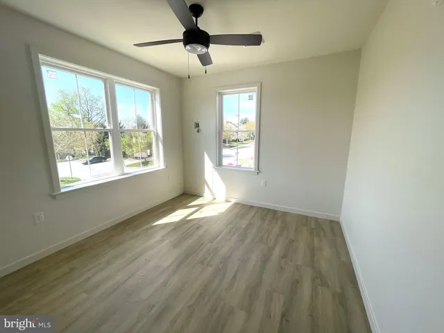 a view of hallway with a large window and wooden floor