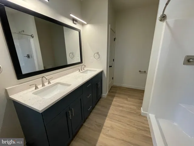 an empty room with wooden floor ceiling fan and windows