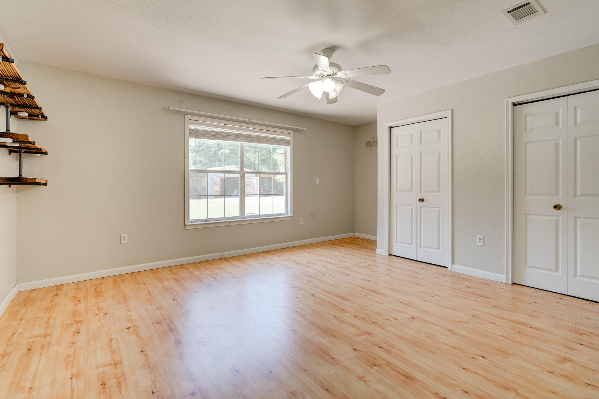 4236 Edge Perry Road Crestview, FL 32539 - Photo 16 of 51 a view of an empty room with wooden floor and a window