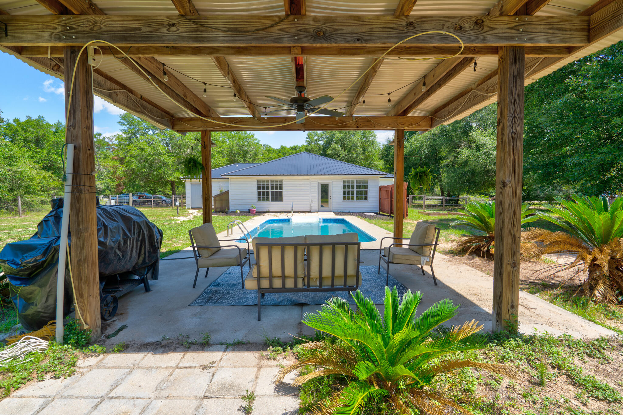 4236 Edge Perry Road Crestview, FL 32539 - Photo 24 of 51 a view of a patio with table and chairs potted plants with wooden floor and roof