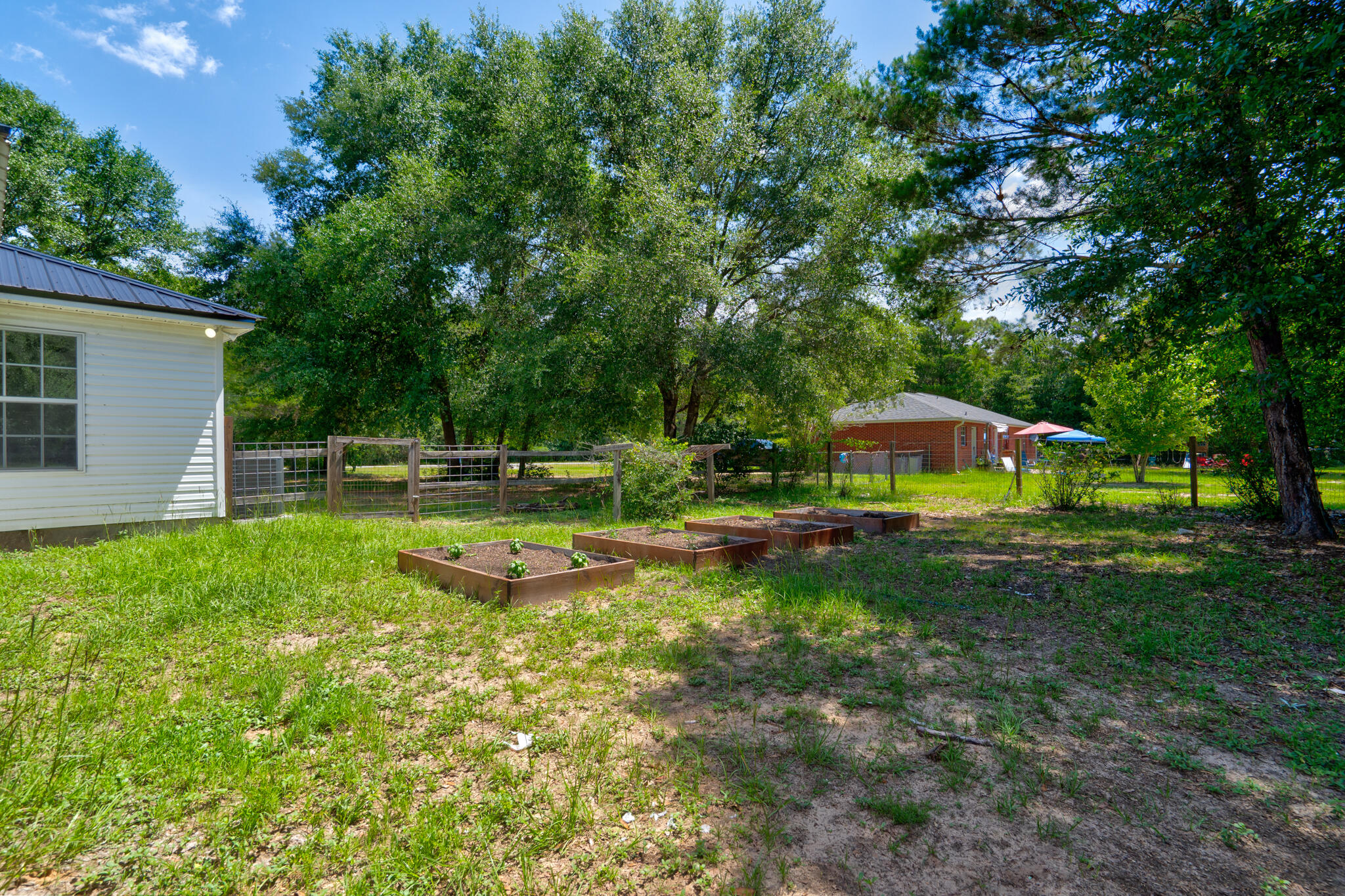 4236 Edge Perry Road Crestview, FL 32539 - Photo 29 of 51 a view of a swimming pool with a table and chairs under an umbrella