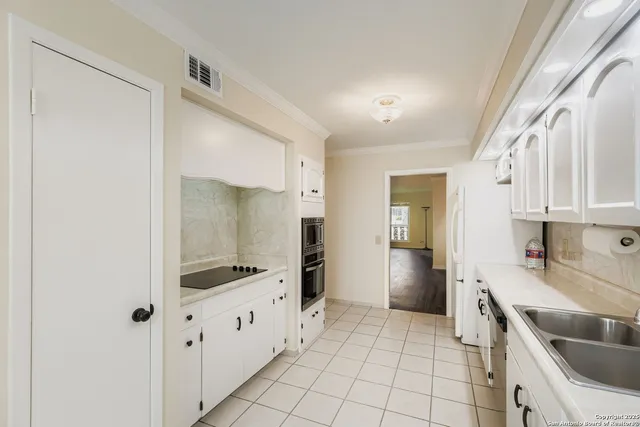a kitchen with white cabinets and stainless steel appliances
