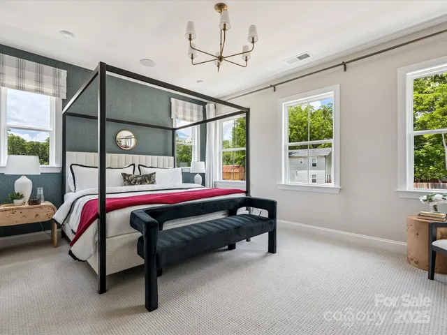 a bed sitting in a bedroom next to a window