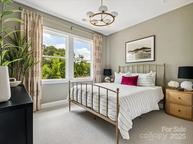 a bed sitting in a bedroom next to a window