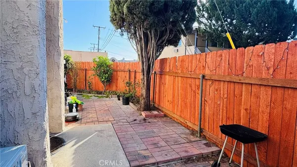 a view of backyard with a table and chairs and wooden fence