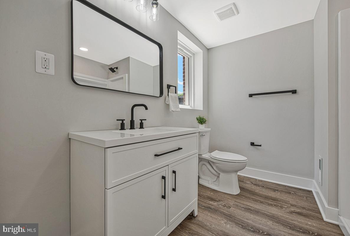 2105 Queens Chapel Road Mount Rainier, MD 20712 - Photo 25 of 33 a bathroom with a toilet a sink and mirror
