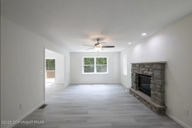 a living room with furniture a fireplace and a large window