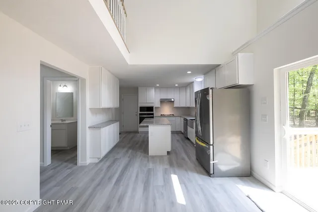 a kitchen with stainless steel appliances granite countertop a sink a refrigerator and a granite counter tops