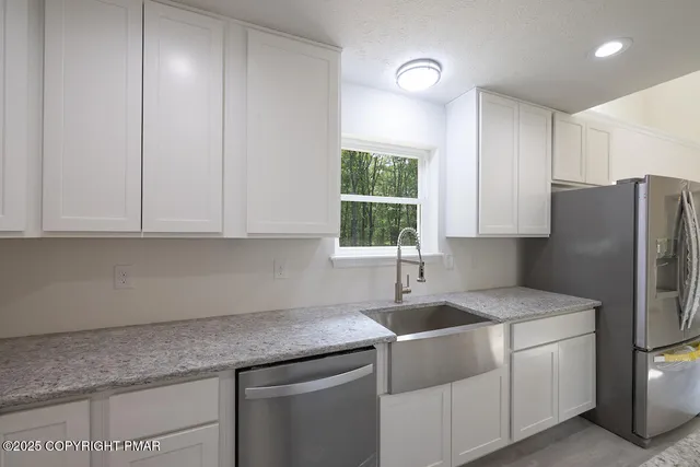 a kitchen with granite countertop a stove and a sink