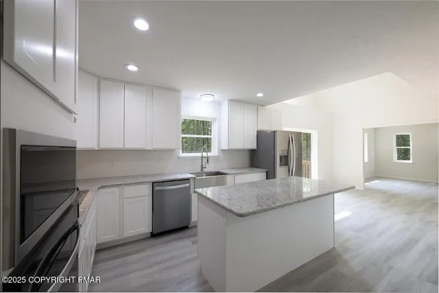 a kitchen with stainless steel appliances granite countertop a refrigerator sink and cabinets
