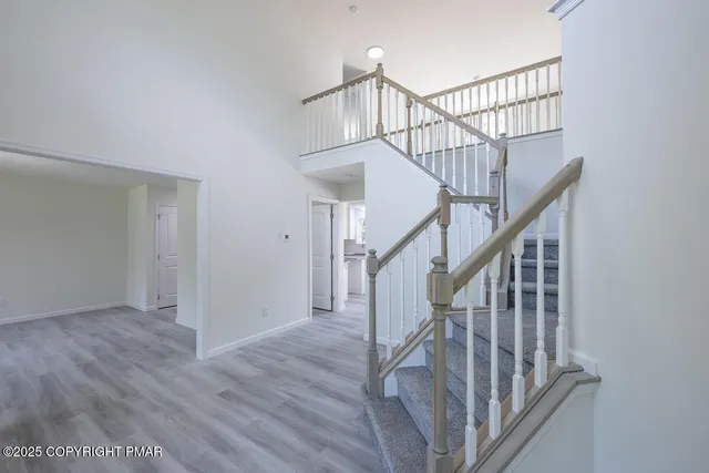 a view of an empty room with a chandelier fan