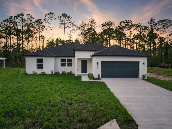 a front view of a house with a garden and yard