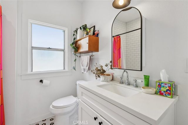 a bathroom with a sink vanity mirror and toilet
