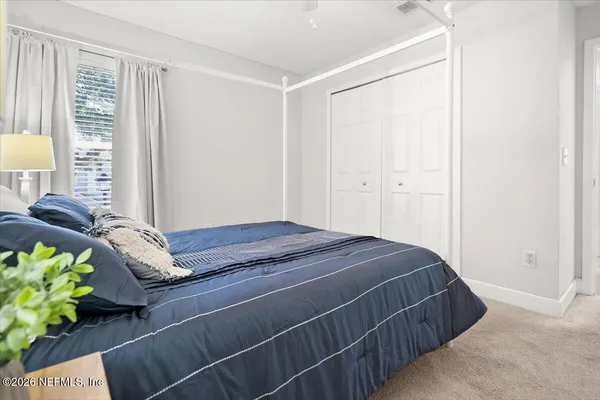 a bed sitting in a bedroom next to a window