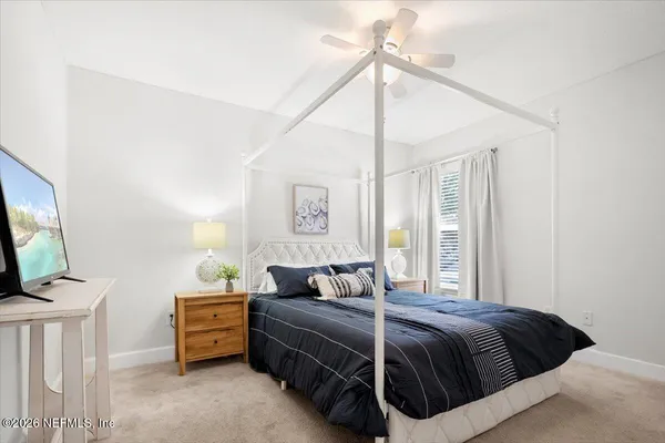 a bedroom with a bed window and a flat screen tv