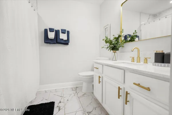 a bathroom with a sink toilet and mirror