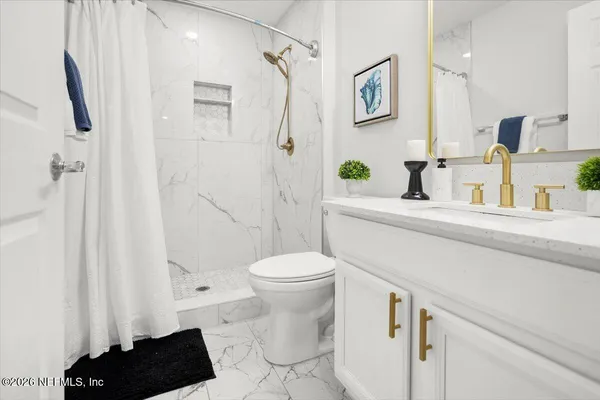 a bathroom with a sink a toilet and a shower