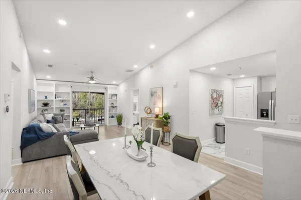 a large white kitchen with a large window and stainless steel appliances