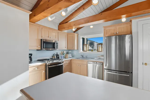 a kitchen with stainless steel appliances granite countertop a refrigerator stove microwave and sink