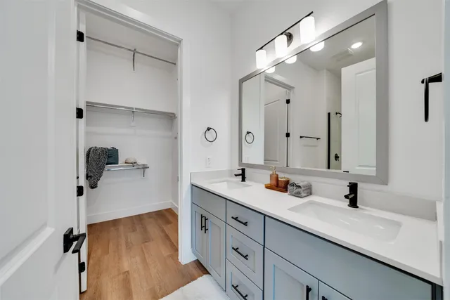 a bathroom with a double vanity sink mirror and shower
