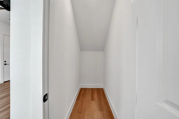 a view of a hallway with wooden floor
