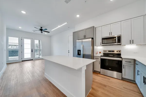 a large kitchen with stainless steel appliances granite countertop a stove and a refrigerator