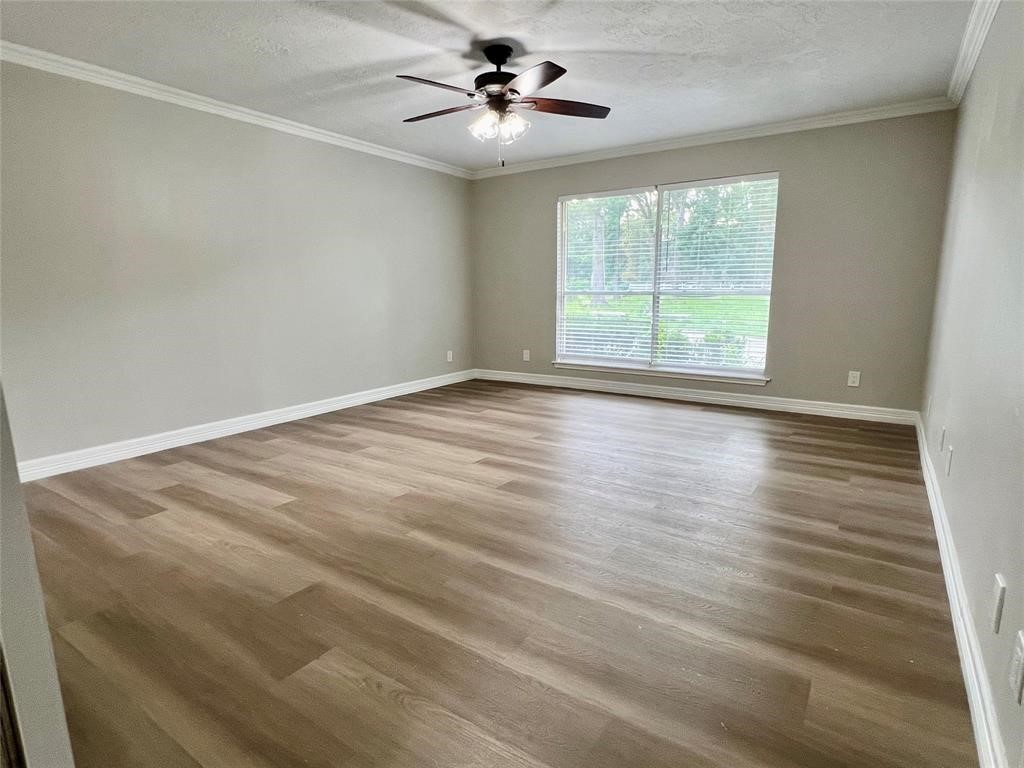 14221 Horseshoe Bend Conroe, TX 77384 - Photo 14 of 21 an empty room with wooden floor and windows