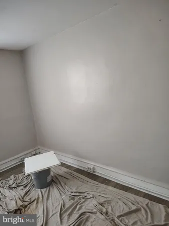 a view of a room with a bed and wooden floor