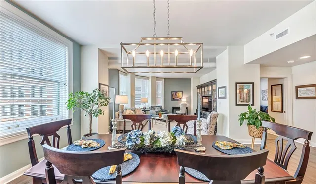 a bedroom with a bed and large window with wooden floor